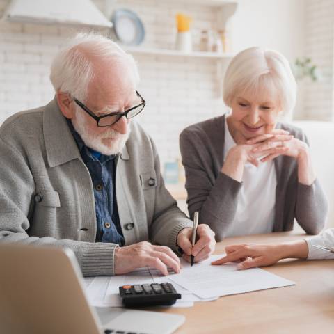 Un couple de seniors remplit le dossier d'APA à domicile.